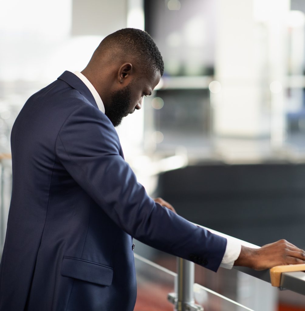 Stressed african american entrepreneur standing by railing
